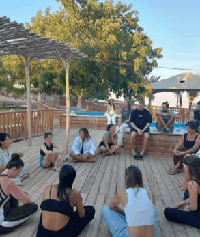 young people sat in a circle, outdoor recreational area